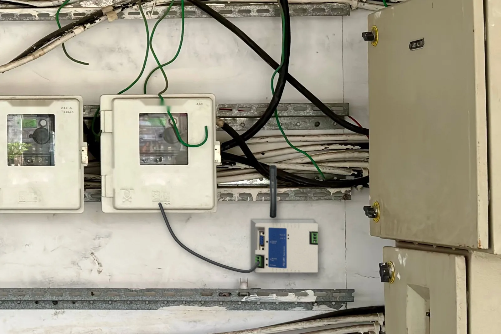 RD-485 installé à côté d'un mur de compteurs dans un local électrique, câble RS485 vers l'armoire de comptage