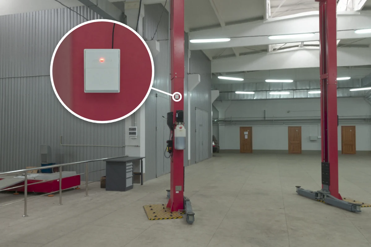 Two-post vehicle lift in a car service shop with CS-732F wireless remote receiver on the column for remote up/down control