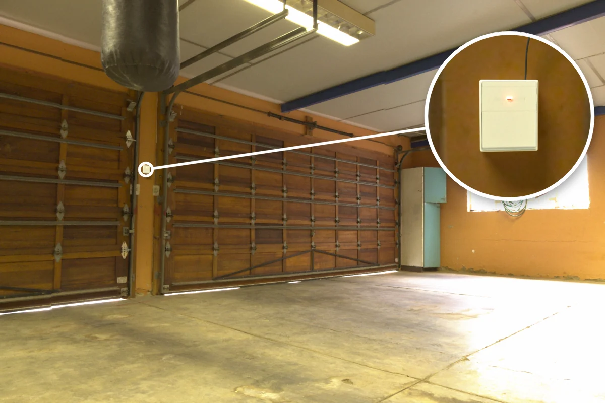 Warehouse roller shutter with CS-732F wireless remote receiver on the wall beside it for remote up/stop/down